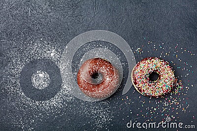 Pastry background. Chocolate donut or doughnut on black table top view. Flat lay. Copy space for text. Stock Photo