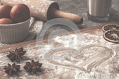 Pastry board with heart flour on the concrete countertop with eggs in the white bowl Stock Photo