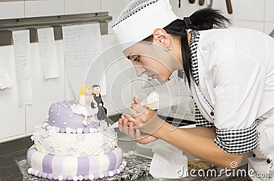 Pastry chef decorates a cake Stock Photo