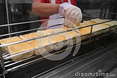 Pastry chef toasting bread on iron griddles. Preparing food process for customers Stock Photo