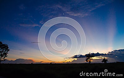 Pasture silhouette with a colorful sunset background Stock Photo