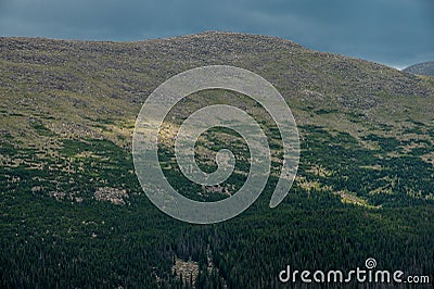 Patch of Sunlight Breaks Through The Clouds to Light The Hills Side Stock Photo