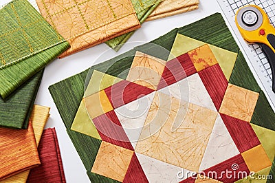 Patchwork orange-green block, quilting fabrics, sewing accessories Stock Photo