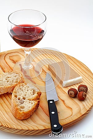 Pate, bread, glass of red wine, hazelnuts and knife on wood plate Stock Photo