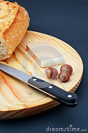 Pate, bread, hazelnuts and knife on wood plate Stock Photo