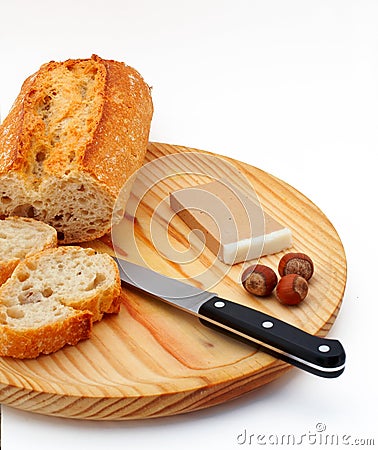 Pate, bread, hazelnuts and knife on wood plate Stock Photo