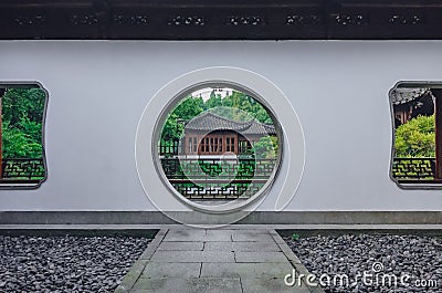 Path leading to moon gate with view of traditional Chinese building, in a Chinese garden, near West Lake, in Hangzhou, China Stock Photo