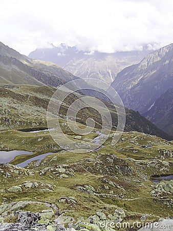 Path on a mountain passing a beautiful view on landscape of the moutains around in background. Stubai valley, austria, Alp. Stock Photo