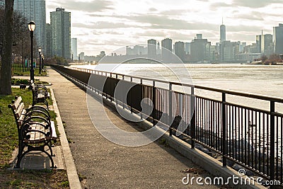 Path with Row of Benches at Queensbridge Park along the East River in New York City Stock Photo