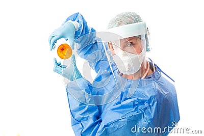 Pathology sceintist in biosecurity suit and PPE holds up a petri dish Stock Photo