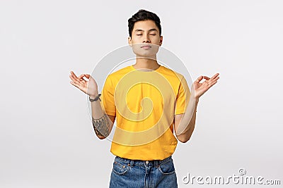 Patience, modern lifestyle concept. Calm and relieved young asian man taking emotions under control, close eyes Stock Photo