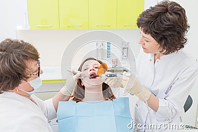 Patient at a dentist office with doctor and assistant, Caries treatment Stock Photo