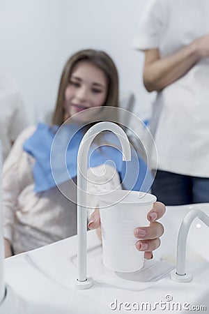 Patient in dentist office taking a cup of water after treatment Stock Photo