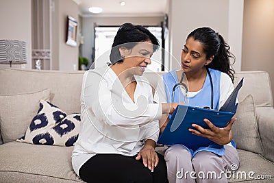 Patient discussing over medical report with doctor Stock Photo