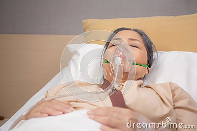 Patient elderly asleep with disease or unconscious in oxygen mask on bed at hospital ward, senior sick urgency. Stock Photo