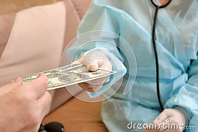 The patient gives the doctor money, a bribe for treatment. The concept of corrupt doctors Stock Photo