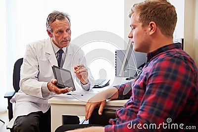 Patient Having Consultation With Male Doctor In Office Stock Photo