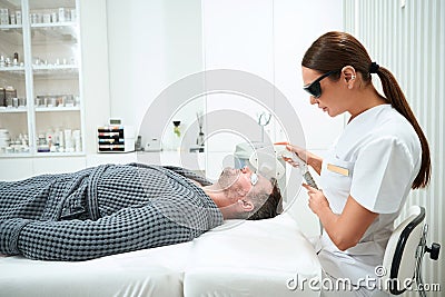Patient lies on a cosmetology couch during the photorejuvenation procedure Stock Photo