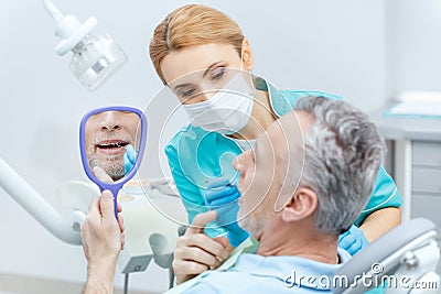 Patient looking at mirror while professional dentist checking teeth Stock Photo