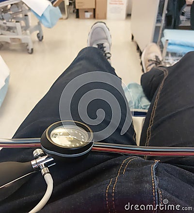 patient lying on hospital bed with manometer for measuring blood pressure Stock Photo