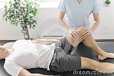 Patient at the physiotherapy doing physical exercises with his therapist Stock Photo