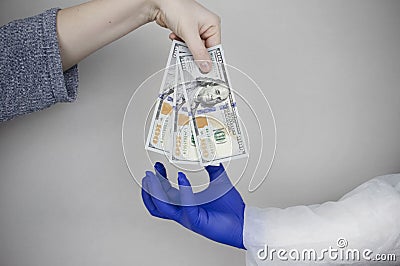 Patients hand holds out money to the doctor. The concept of corruption in healthcare, bribery or paid medicine Stock Photo