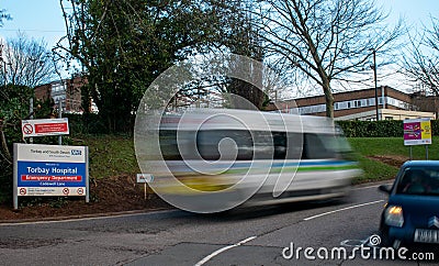 Patient transport ambulance driving into the grounds of Torbay Hospital, Torquay Devon. Editorial Stock Photo