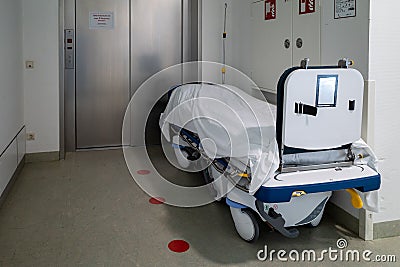 Patient transport bed stands in front of an elevator in a hospital Stock Photo
