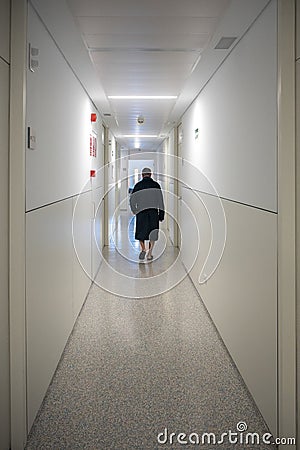 Patient walking alone in a hospital hallway Stock Photo