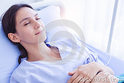 Patient woman feel safe, happy with smile face when sick lady sleep in hospital room. She recuperate for while. Patient female Stock Photo