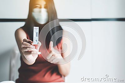 Patient woman showing result a covid-19 self test rapid antigen testing kit at home Stock Photo