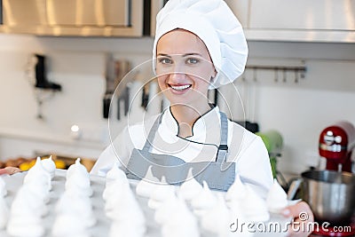 Patissier in her bakery shop with lots of meringue Stock Photo