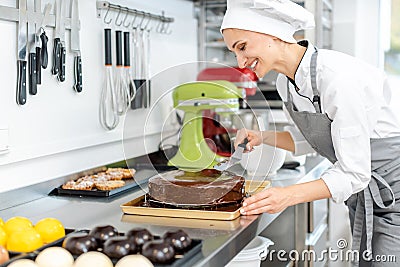 Patissier pouring liquid chocolate on a cake Stock Photo