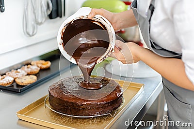 Patissier pouring liquid chocolate on a cake Stock Photo