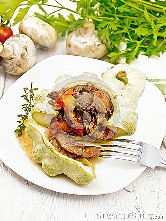 Patisson stuffed with liver and mushrooms in plate on board Stock Photo