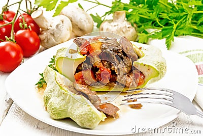Patisson stuffed with liver and mushrooms in plate on wooden board Stock Photo