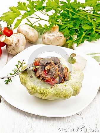 Patisson stuffed with liver and vegetables in plate on light board Stock Photo