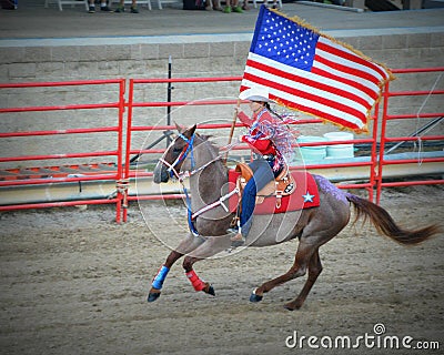 Patriotic Cowgirl on Horseback with Flag Editorial Stock Photo