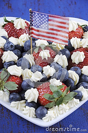 Patriotic red, white and blue berries with fresh whipped cream stars and USA flag. Stock Photo