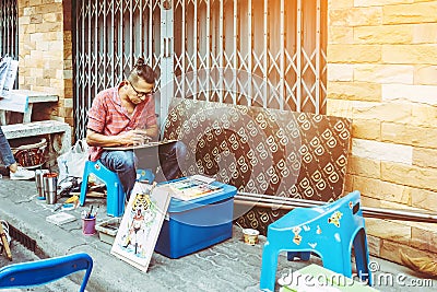 PATTAYA THAILAND - FEBRUARY 22 : Unidentified street male artist draws portrait and and sells graphic arts at Baan Sak Ngaew Editorial Stock Photo