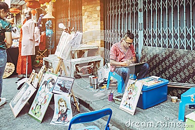 PATTAYA THAILAND - FEBRUARY 22 : Unidentified street male artist draws portrait and and sells graphic arts at Baan Sak Ngaew Editorial Stock Photo