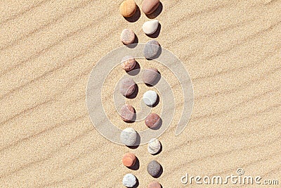 Pattern of colored pebbles on clean sand. Zen background, harmony and meditation concept Stock Photo