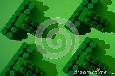 Pattern of large plastic blocks of a children`s constructor on a green background. Child development concept, logic, thinking and Stock Photo