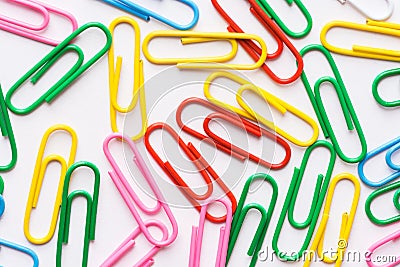 Pattern from multicolored paper clips scattered on white background. School office supplies paperwork documents organization Stock Photo