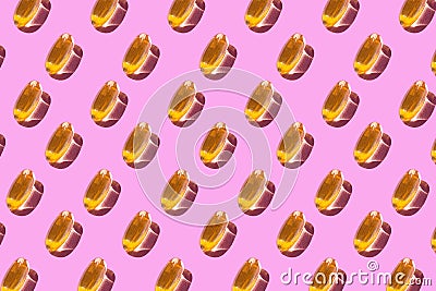 A pattern of omega 3 capsules on a light pink background. Wrapping paper. Design background Stock Photo