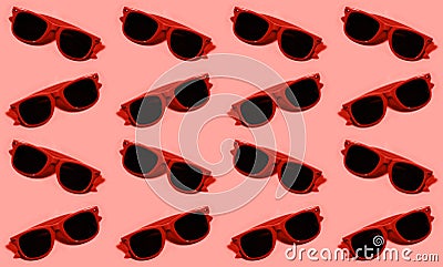 Pattern of red plastic sunglasses on background of pastel red color. Stock Photo