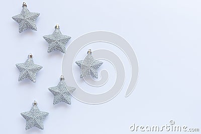 Pattern of silver glittery Christmas star ornaments on white background with copy space Stock Photo