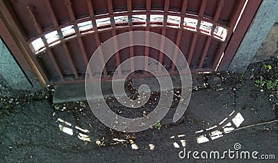 Pattern of sunspots on the ground and on the shady side of the fence. Stock Photo