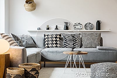 Patterned pillows on grey couch in modern living room interior w Stock Photo