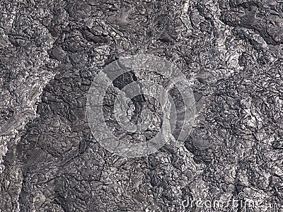Patterns cracks and shapes emerge from this close up portion of black solidified lava Stock Photo